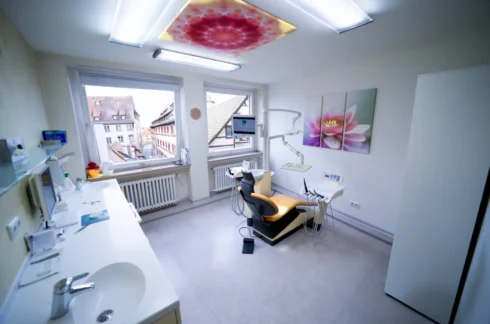 Modern eingerichteter Behandlungsraum mit Zahnarztstuhl und Fensterblick