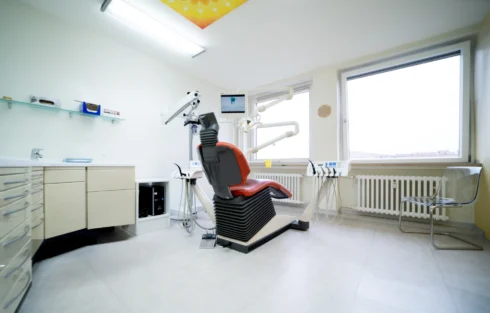 Modern eingerichteter Behandlungsraum mit Zahnarztstuhl und Fensterblick
